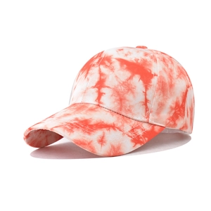 Detail of starry gradient baseball cap featuring orange and white tie-dye cotton fabric