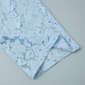Close-up of intricate light blue floral lace fabric with delicate hollow out texture