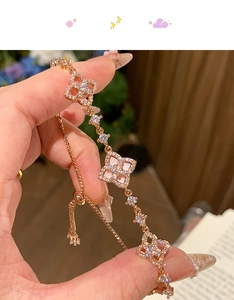 Detail of rose gold clover bracelet with zircon stones and adjustable pull chain