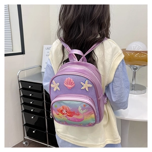 Detail of girls' mermaid backpack with sequins and shell patches on a young model