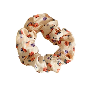 Floral print satin scrunchie with orange and purple flowers on a cream base