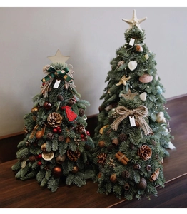 Three mini Christmas trees featuring pine cones, cinnamon sticks, and ocean shells