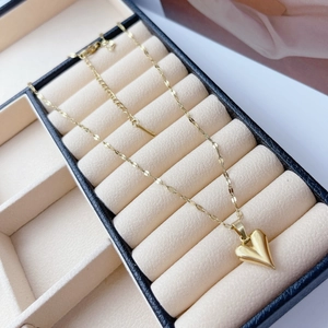 Close-up of a golden heart pendant necklace inside a luxury velvet jewelry box
