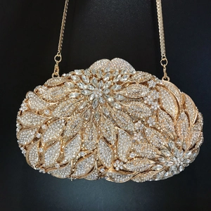 Macro detail of luxury gold floral evening clutch bag with sparkling rhinestone inlay