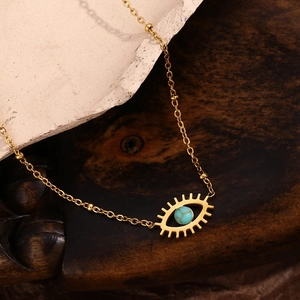 Macro detail of 18K gold-plated evil eye necklace with turquoise stone inlay