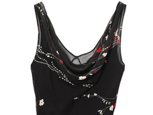 Détail de robe en soie noire avec col bénitier et imprimés floraux sur tissu en mousseline