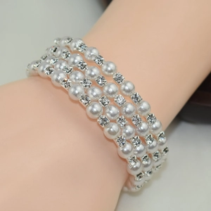 Close-up of four-layer pearl bracelet with square rhinestones worn on wrist