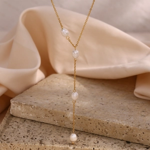 Detail of a gold-plated Y-shaped chain necklace featuring four natural freshwater pearls