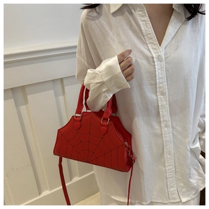Detail of red PU leather handbag featuring black spider web pattern and metal clasps
