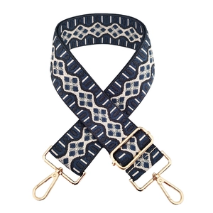 Detailed view of adjustable geometric blue and white jacquard strap with gold metal hooks