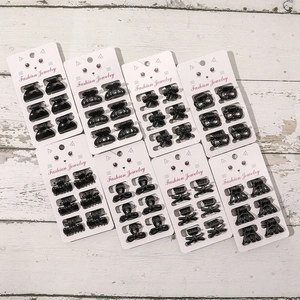 Set of 48 mini black hair claws in diverse geometric shapes displayed on paper cards