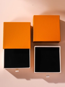 Top view of bright orange drawer jewelry boxes with black velvet insert and white silk pull