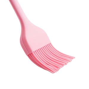 Pink silicone pastry brush for baking with heat-resistant flexible bristles on white background