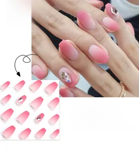 Detail of short coffin press-on nails featuring pink gradient and diamond accents