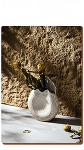 Detailed texture of white wabi-sabi ceramic vase with golden swirl and dried roses