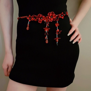 Detailansicht der roten Acryl-Blumen-Taillenkette mit Kristallen auf schwarzem Kleid