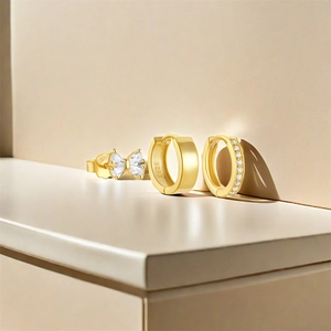 Detail of S925 sterling silver gold earring set with bow stud and hoop earrings