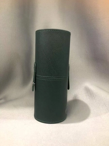 Close-up of dark green faux leather makeup brush holder with metal snap fastener