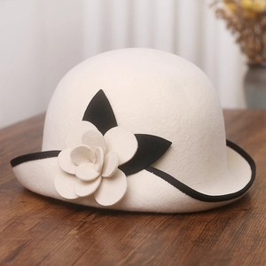 Detail of elegant wool felt hat featuring a 3D camellia flower and black contrast trim