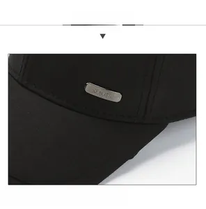Detail view of the black baseball cap showing the silver G HATS metal plaque and stitching