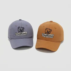 Kids cotton baseball caps featuring cartoon bear embroidery in blue and mustard colors