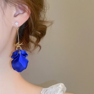 Close-up of long tassel earrings with royal blue petals and sparkling zircon studs