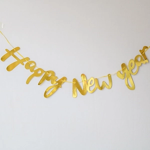 Detail of metallic gold Happy New Year banner letters hanging on a white wall