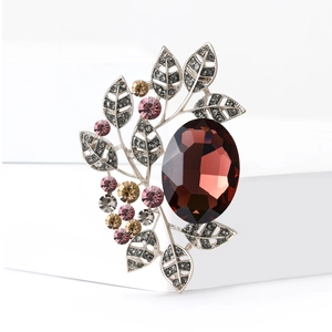 Vintage leaf brooch with large red oval gemstone and pink crystal accents in silver