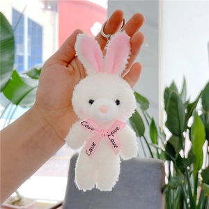 Detail of white plush rabbit keychain with pink Love ribbon and silver metal ring