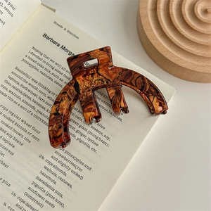 Close-up of tortoise shell pattern acetate claw clip on a vintage recipe book