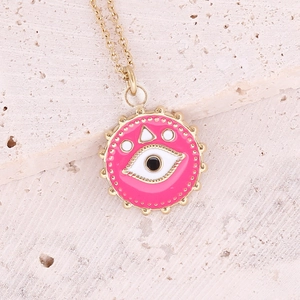 Golden necklace featuring pink enamel evil eye pendant on a textured stone surface