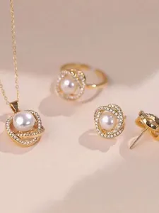 Dettaglio di un elegante set di gioielli in perle dorate con collana e anello