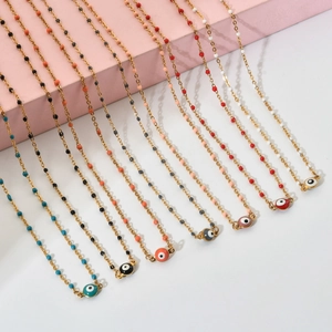 Detail of colorful evil eye pendants on gold-plated chains with matching accent beads