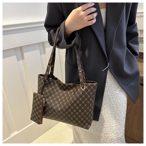 Detail view of brown vintage tote bag with pattern, small pouch, and gold hardware