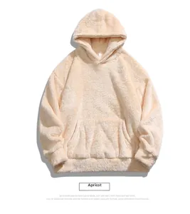 Detail of soft apricot fleece hoodie showing kangaroo pocket and ribbed cuffs