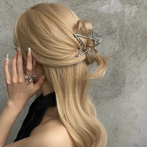 Detailed view of a silver Y2K star-shaped hair claw clip with rhinestones on hair