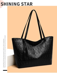 Detail of gothic skull embossed tote bag with elegant leather tassel in studio setting
