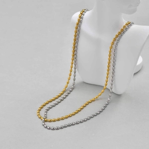 Detail view of 3/5mm gold and silver titanium steel bead necklaces on a display bust