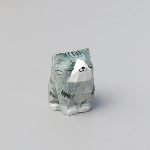 Handcrafted grey and white striped wooden cat ornament with a peaceful sitting posture