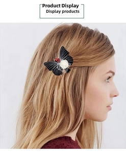 Detail of butterfly hair clip with white rose and ladybug on black striped wings