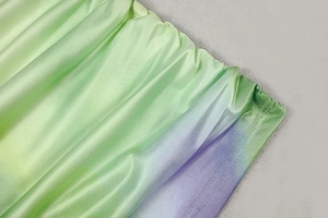 Close-up of green and purple gradient satin fabric with clear stitching and double-edge seams