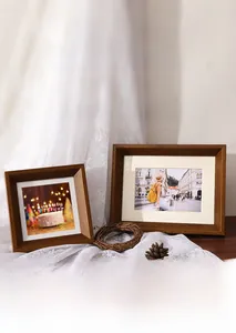 Solid walnut wood picture frames on white lace with dry pine cones and vintage decor