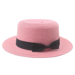 Close-up of pink straw boater hat with a black grosgrain ribbon bow decoration