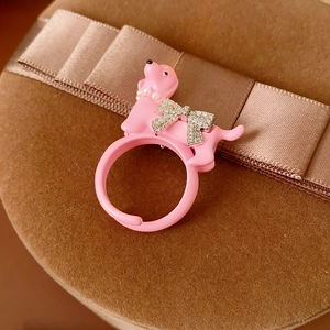 Detail of pink poodle ring with tiny pearls and a sparkling bow on a gift box