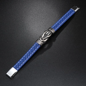 Detailed close-up of blue braided leather bracelet with silver metal knot and magnetic clasp