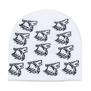 Detailed close-up of white knit beanie featuring black jacquard abstract letter pattern