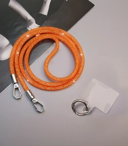 Detail of orange rhinestone mesh crossbody phone strap with silver metal lobster clasps