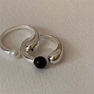 Detailed macro view of 925 silver open rings featuring black and white pearl accents