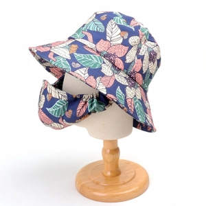 Dettaglio cappello parasole floreale blu marino e maschera abbinata su manichino