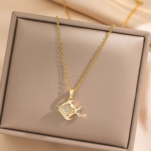 Elegant gold fish pendant necklace with clear crystals on a premium beige jewelry box